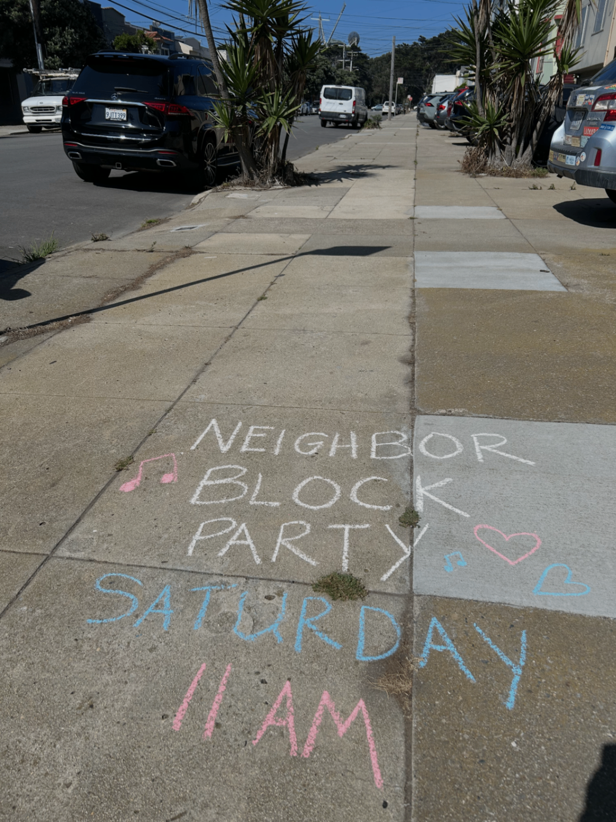 Chalk sign announcing neighbor block party